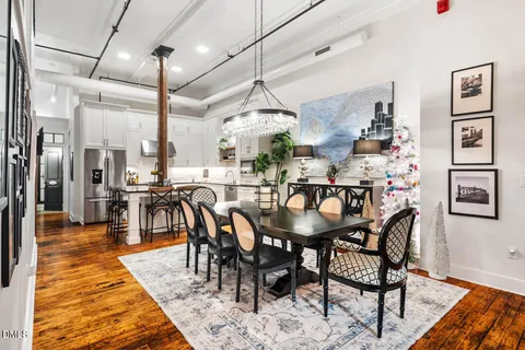 a dining room with stainless steel appliances granite countertop a dining table chairs and couches