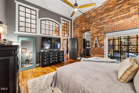 a large bedroom with bed and a large window