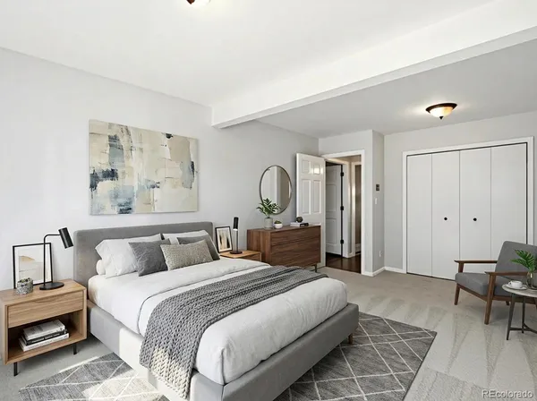 a bedroom with a bed a couch and a chandelier