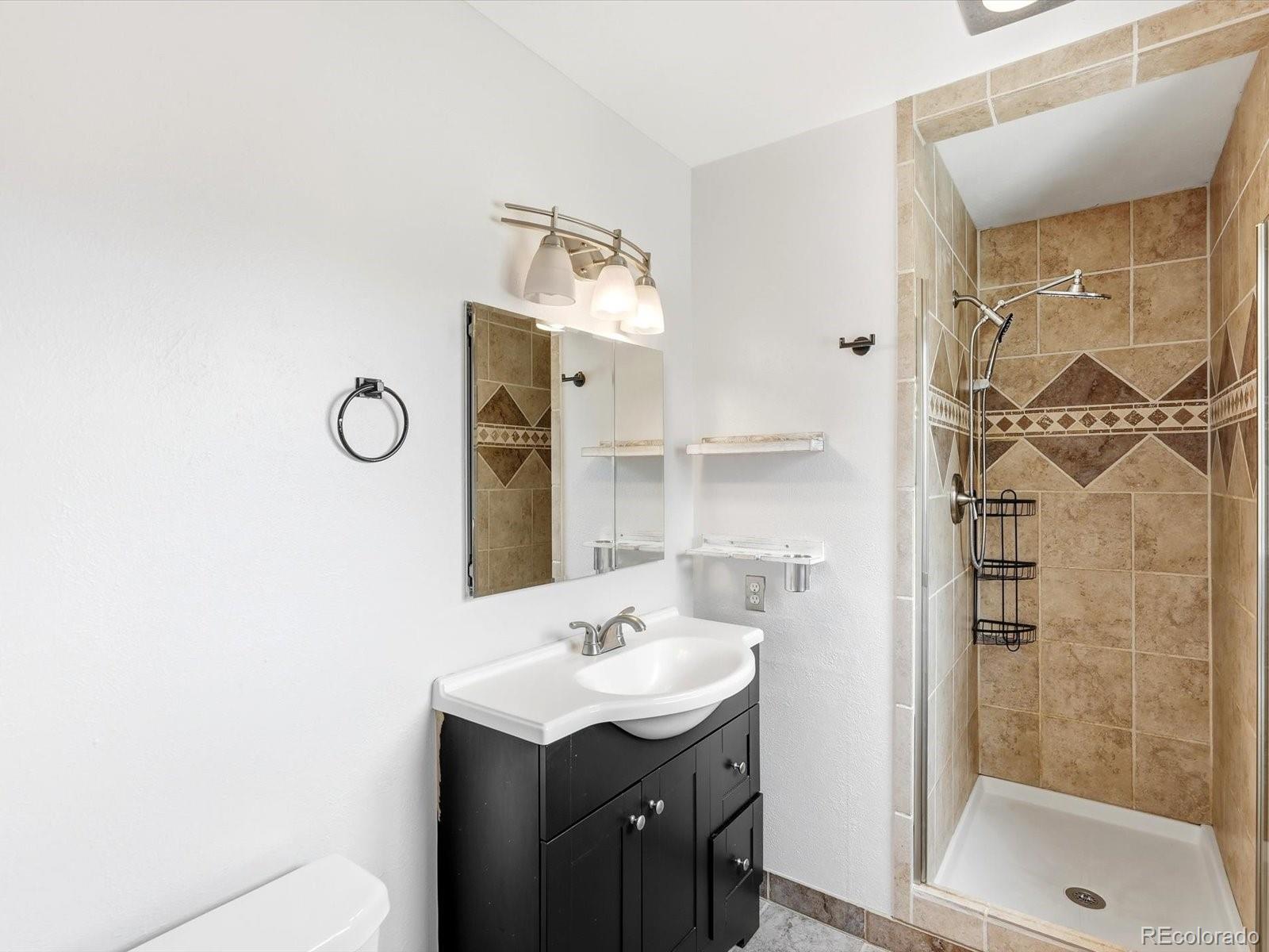 7750 East Greenland Road Franktown, CO 80116 - Photo 30 of 48 a bathroom with a sink mirror and shower