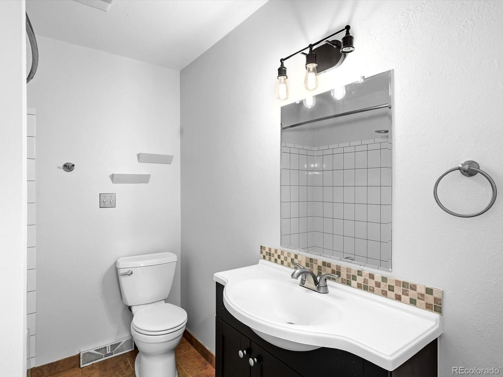 7750 East Greenland Road Franktown, CO 80116 - Photo 32 of 48 a bathroom with a sink a toilet and shower