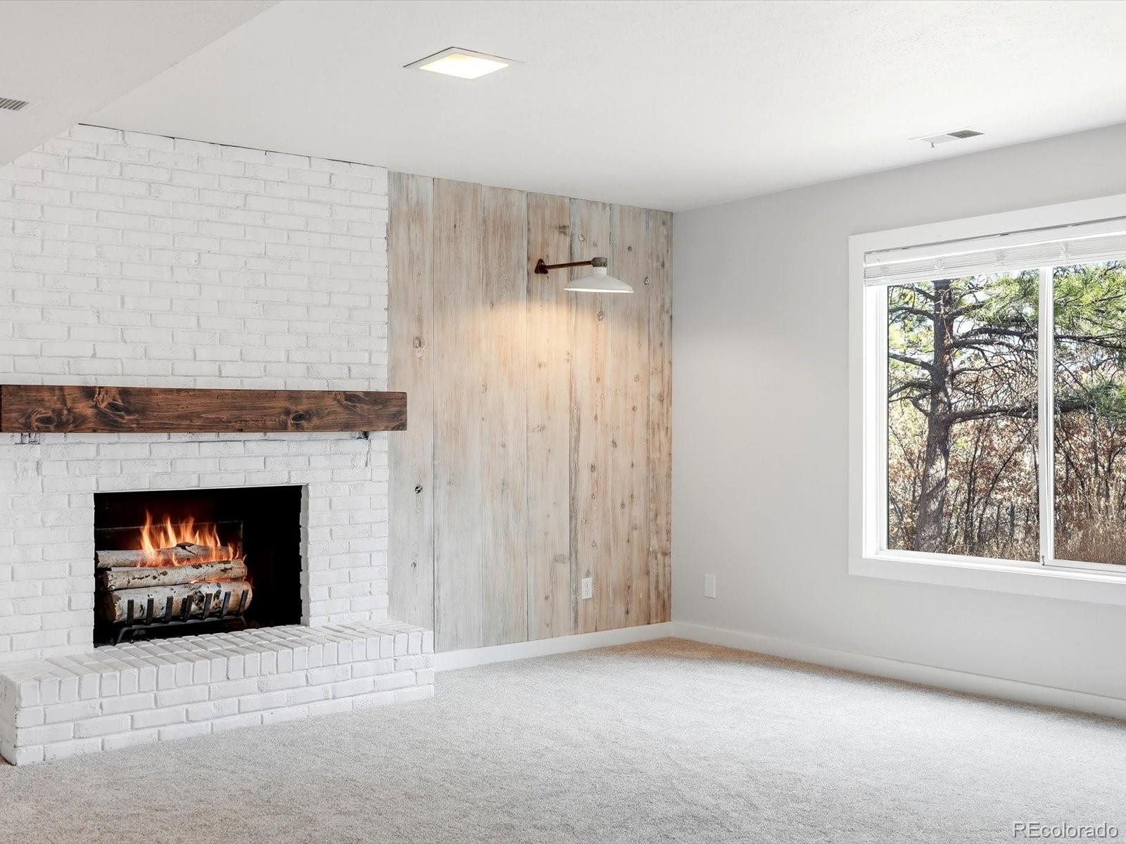 7750 East Greenland Road Franktown, CO 80116 - Photo 36 of 48 an empty room with windows and a fireplace
