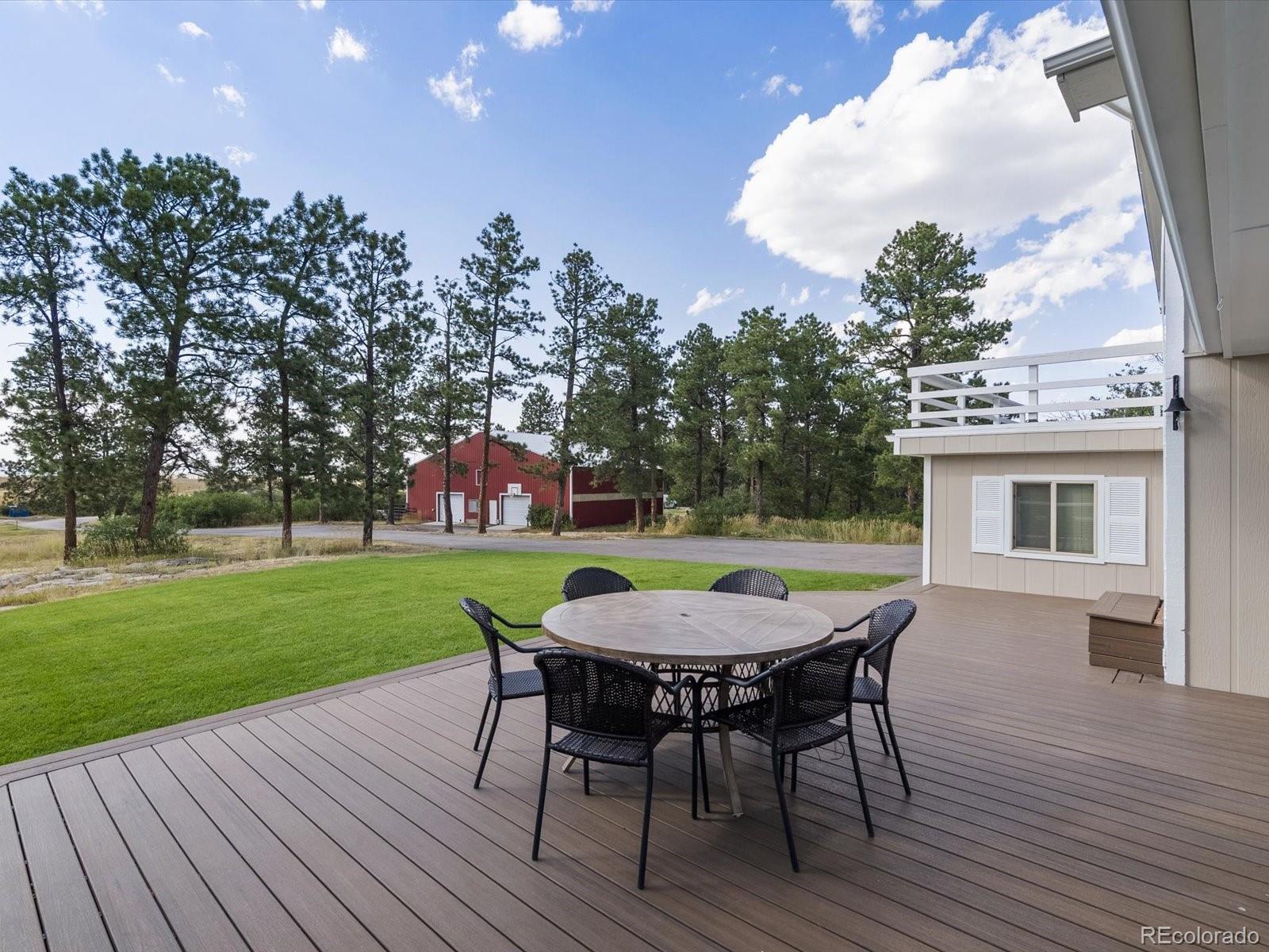 7750 East Greenland Road Franktown, CO 80116 - Photo 9 of 48 a view of a wooden dinning table and chairs in patio of the house
