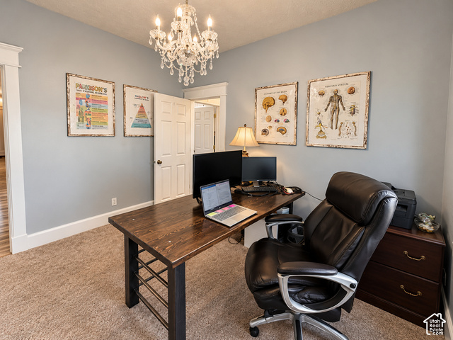 1750 West 4100 North Helper, UT 84526 - Photo 18 of 50 Neutral-toned wall paint, decorative chandelier light fixture, wood-finish desk with black metal frame, and light brown carpet flooring