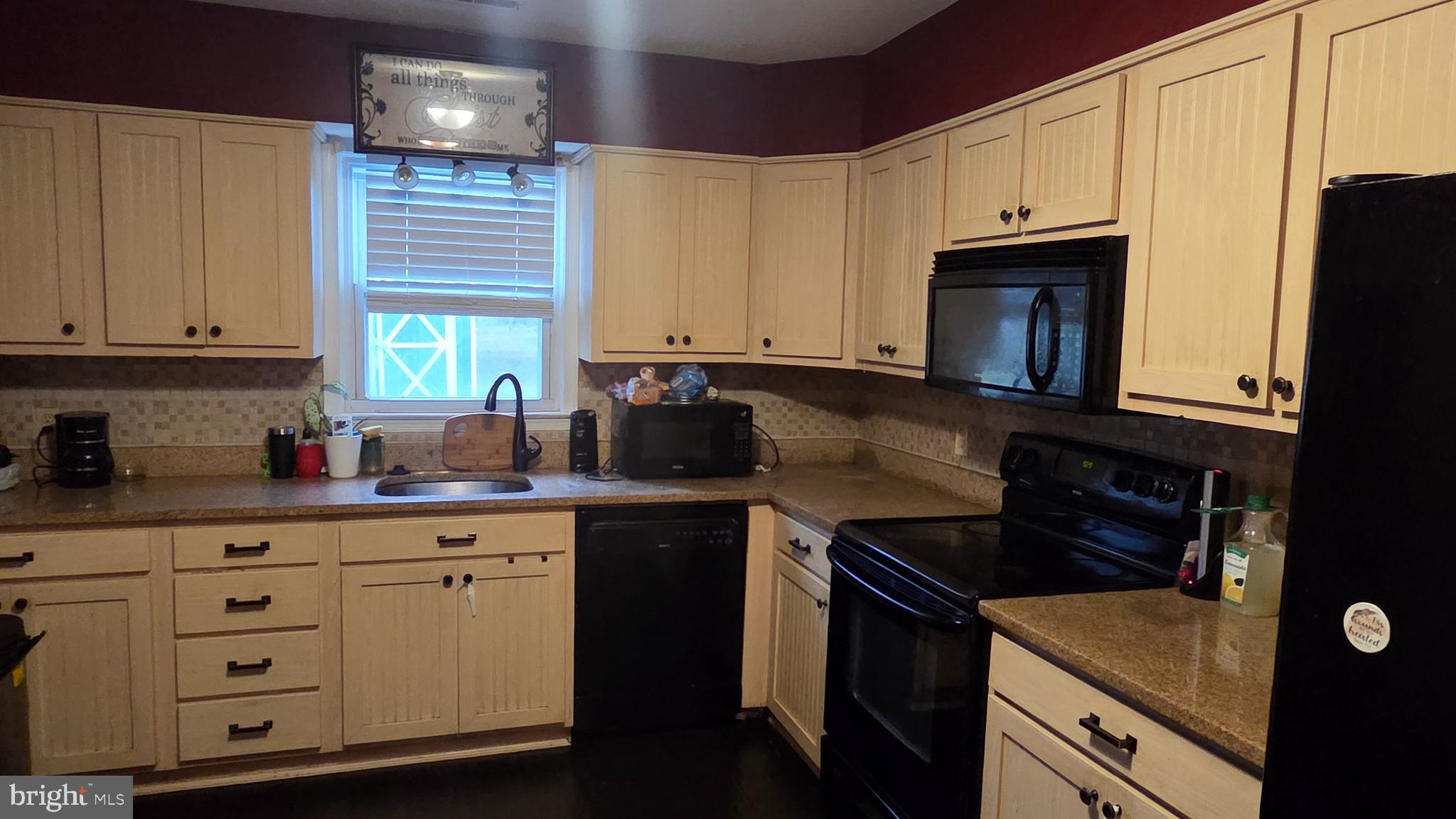 9104 Trumps Hill Road Upper Marlboro, MD 20772 - Photo 7 of 11 a kitchen with granite countertop white cabinets and black stainless steel appliances