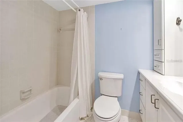 a white toilet sitting next to a bath tub