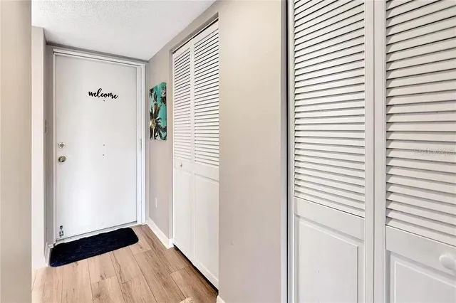 a view of a hallway with wooden floor and windows