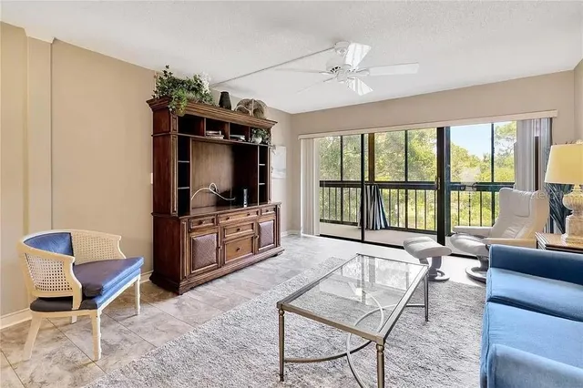 a living room with furniture a flat screen tv and a floor to ceiling window