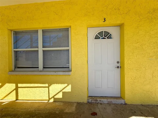 a view of front door of yellow house