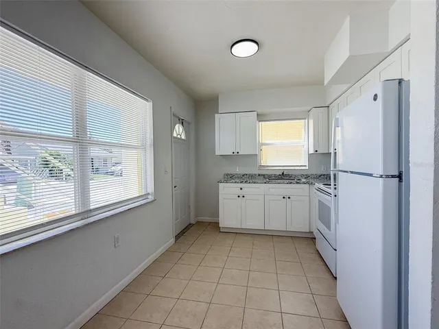 a kitchen with a refrigerator sink and cabinets