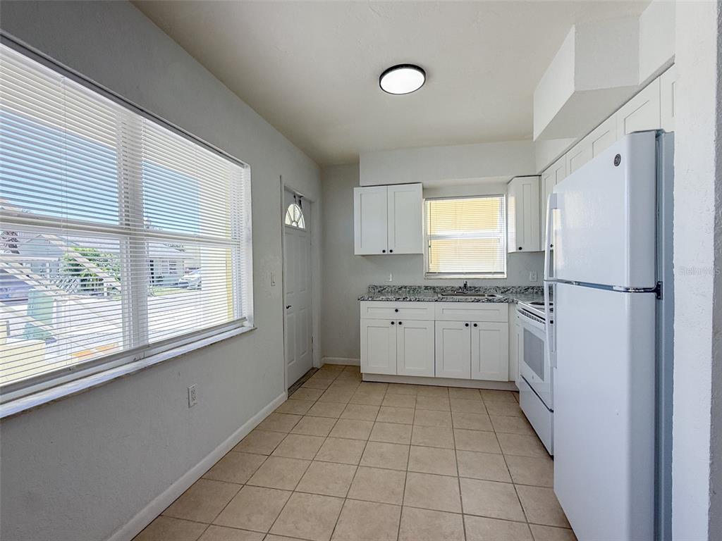 111 177th Avenue West, Unit 3 Redington Shores, FL 33708 - Photo 5 of 16 a kitchen with a refrigerator sink and cabinets