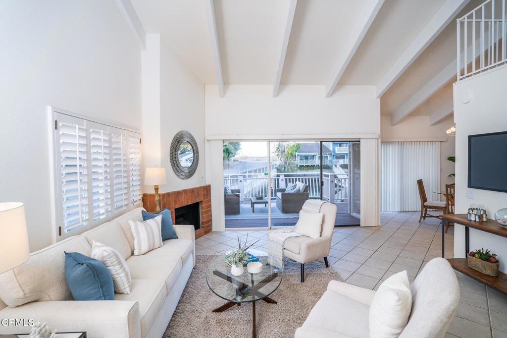 4625 Falkirk Bay Oxnard, CA 93035 - Photo 8 of 37 a living room with furniture a fireplace and a floor to ceiling window