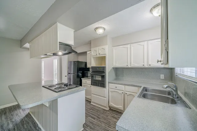 a kitchen with granite countertop a sink stove and refrigerator
