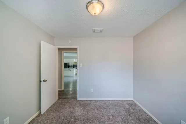 a view of an empty room with window and closet area