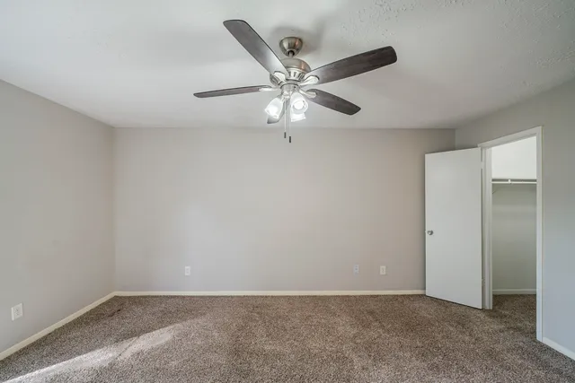 a view of an empty room and a ceiling fan
