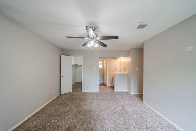 an empty room with fan and windows