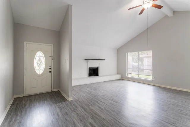 a view of empty room with wooden floor and fireplace
