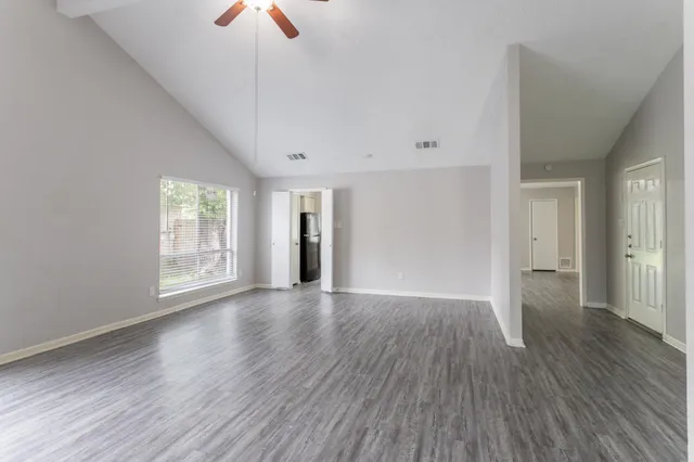 a view of a kitchen with kitchen island a sink wooden floor and a large window