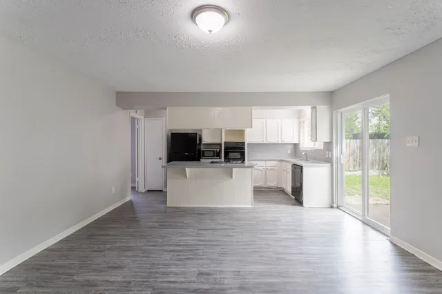 a view of kitchen with stainless steel appliances refrigerator oven and cabinets