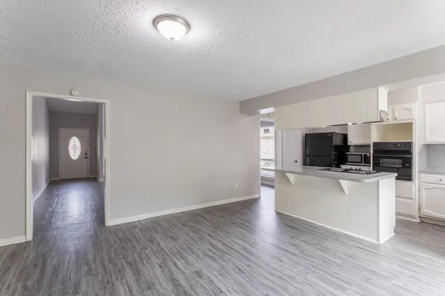 a kitchen with stainless steel appliances kitchen island granite countertop a refrigerator and a sink