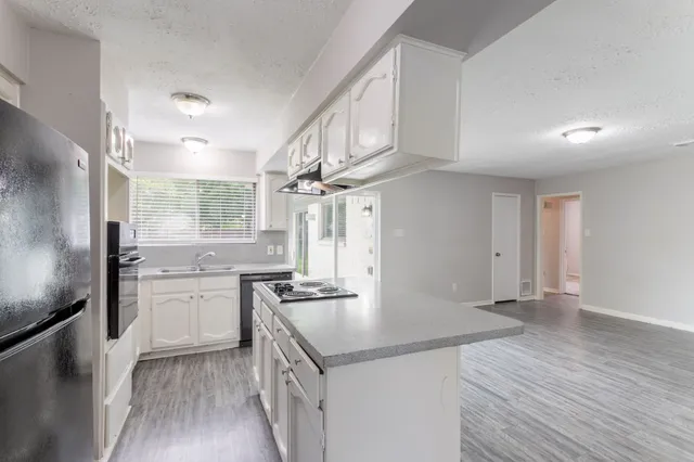 a kitchen with a stove and a wooden floor