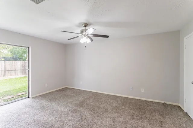 a view of an empty room and a ceiling fan