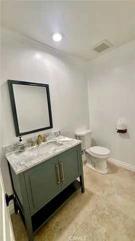 a bathroom with a granite countertop sink a toilet and a shower