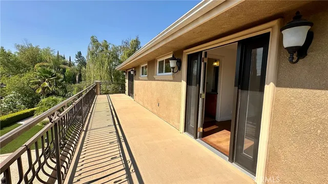 a view of an empty room with wooden floor fireplace and a window