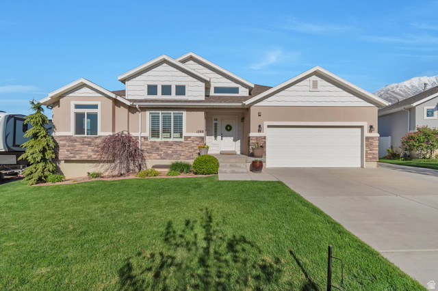 1288 North Horizon View Loop Elk Ridge, UT 84651 - Photo 1 of 40 Craftsman-style home with stone siding, an attached garage, concrete driveway, and a front yard