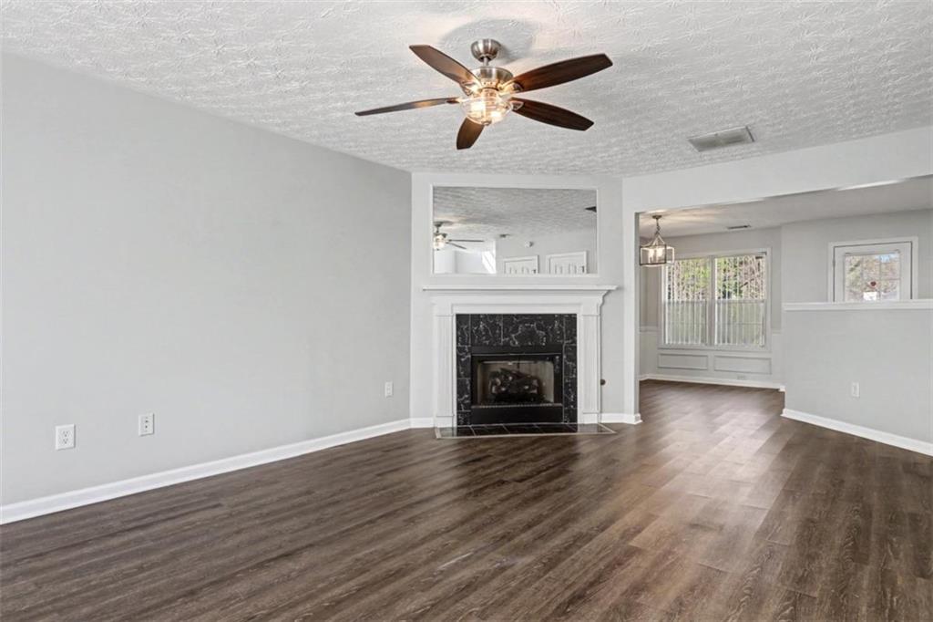 4612 Grand Central Parkway Decatur, GA 30035 - Photo 2 of 10 an empty room with wooden floor a ceiling fan a fireplace and a window