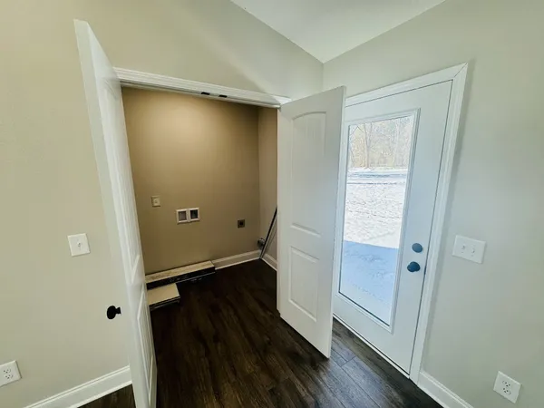 an empty room with wooden floor and entrance