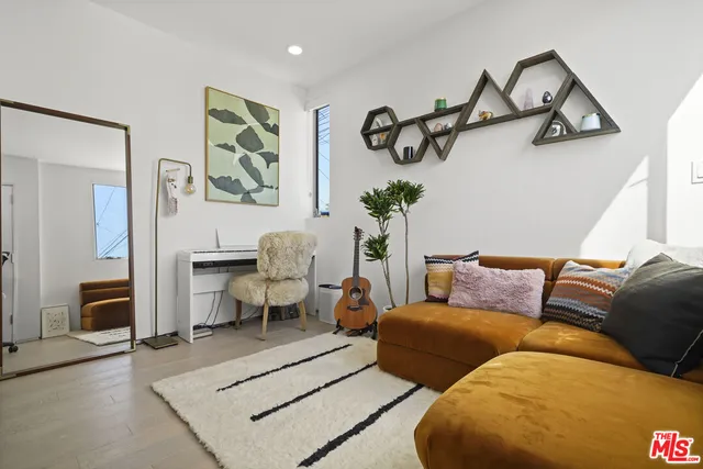 a living room with furniture a rug and wooden floor