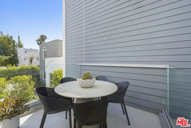 a table and chairs in patio of a house