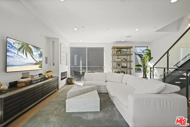 a living room with furniture fireplace and a large window