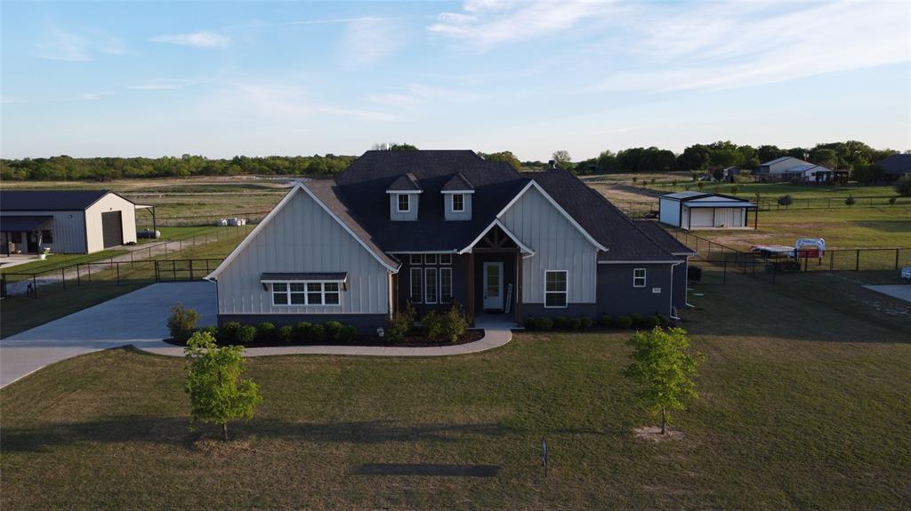 View of front facade with board and batten siding and concrete driveway