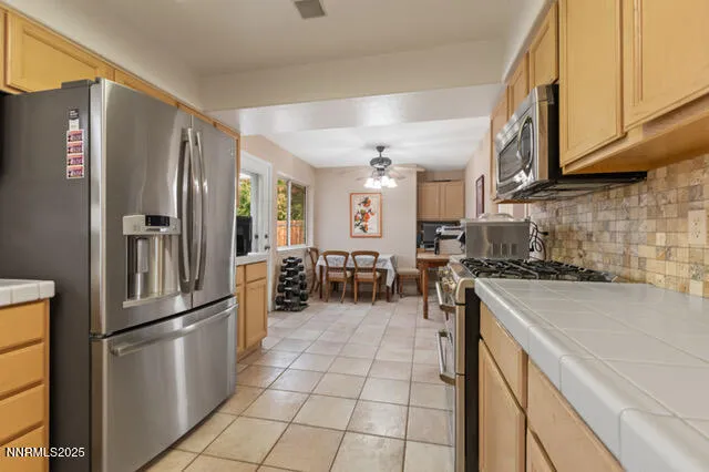 a kitchen with stainless steel appliances granite countertop a refrigerator a stove and a sink