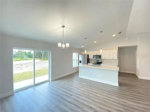 a view of kitchen with kitchen island wooden floor and window
