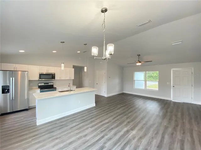 a view of a kitchen with a sink oven refrigerator and microwave