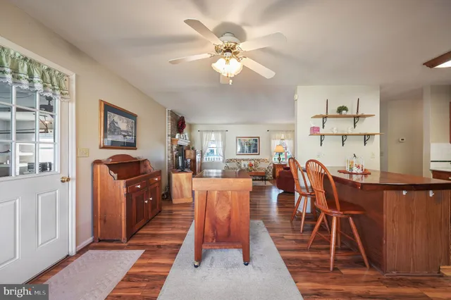 a dining room with wooden floor and a chandelier