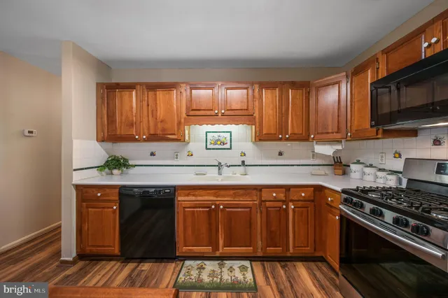 a kitchen with stainless steel appliances a sink stove and cabinets