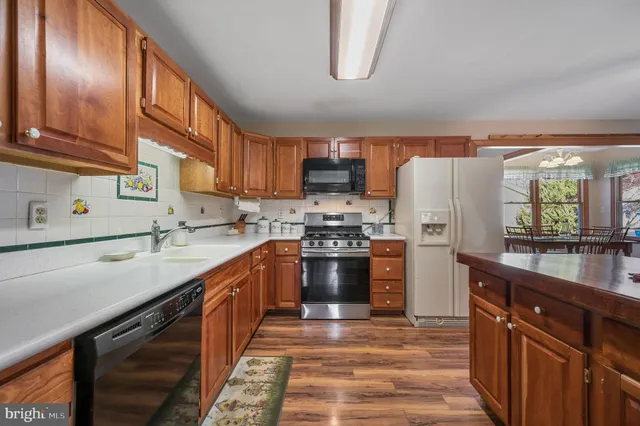 a kitchen with stainless steel appliances granite countertop a refrigerator a stove a sink and a microwave