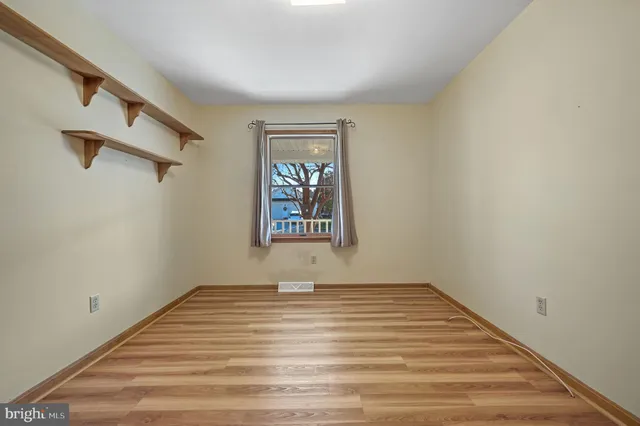 a view of a room with wooden floor and window