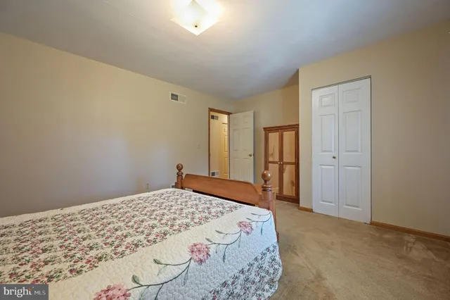 a bedroom with a bed and a refrigerator