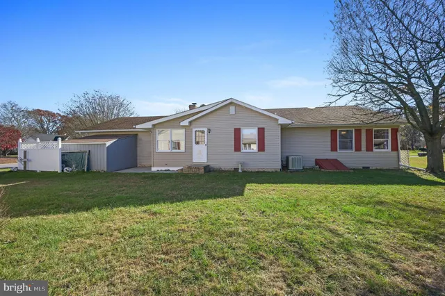 a white house with a big yard and large trees