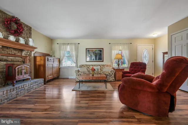 a living room with fireplace furniture and a wooden floor
