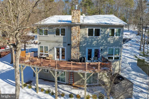 a view of a hallway to a livingroom with wooden floor and windows