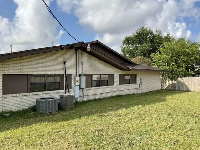 a backyard of a house with yard table and chairs