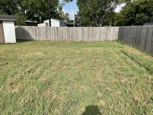 a view of a backyard with a wooden fence