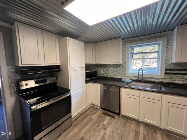 a view of a hallway with wooden floor and closet