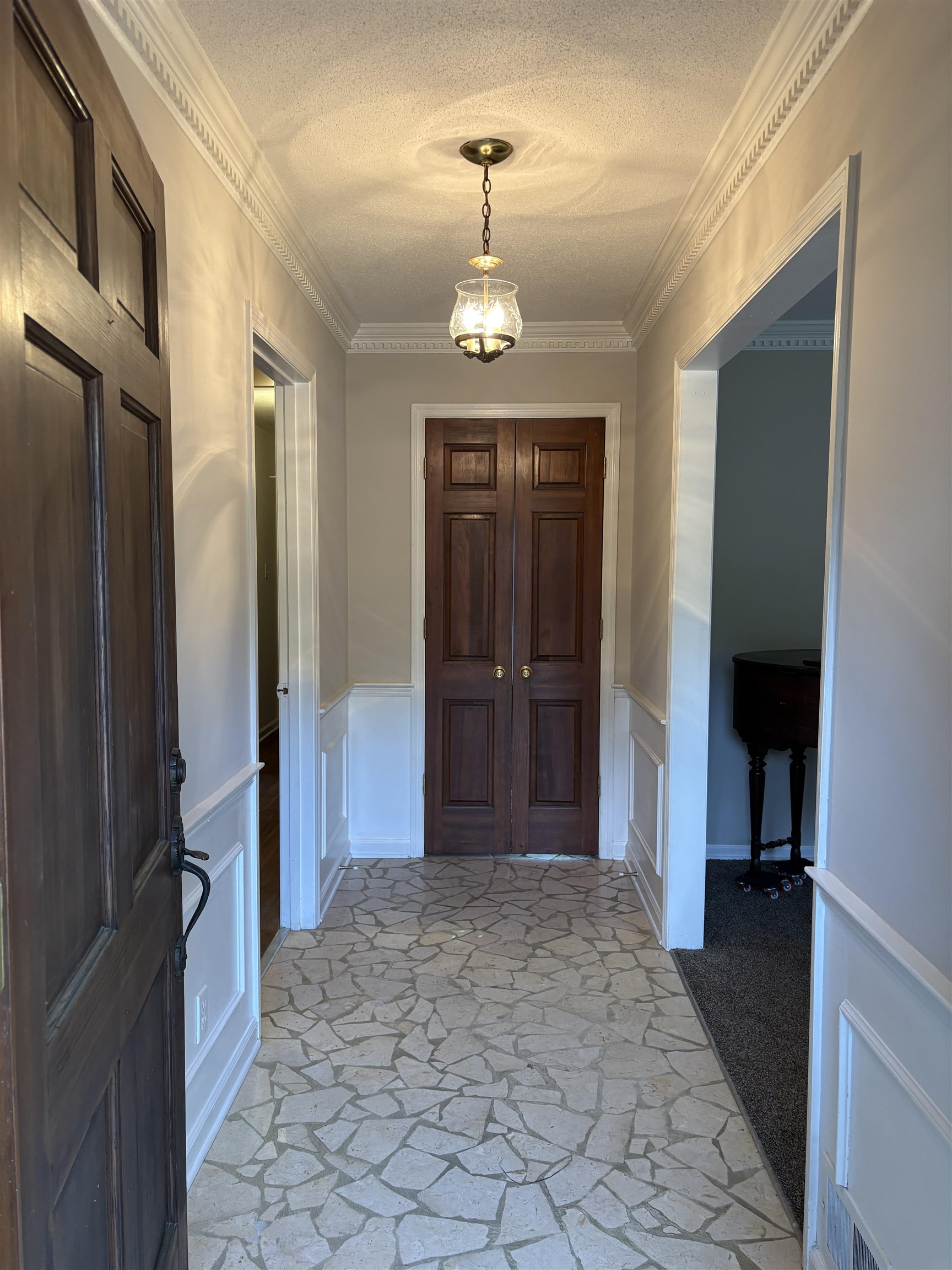 5459 Knight Arnold Road Memphis, TN 38115 - Photo 11 of 38 Foyer featuring a textured ceiling, a decorative wall, wainscoting, and stone floors